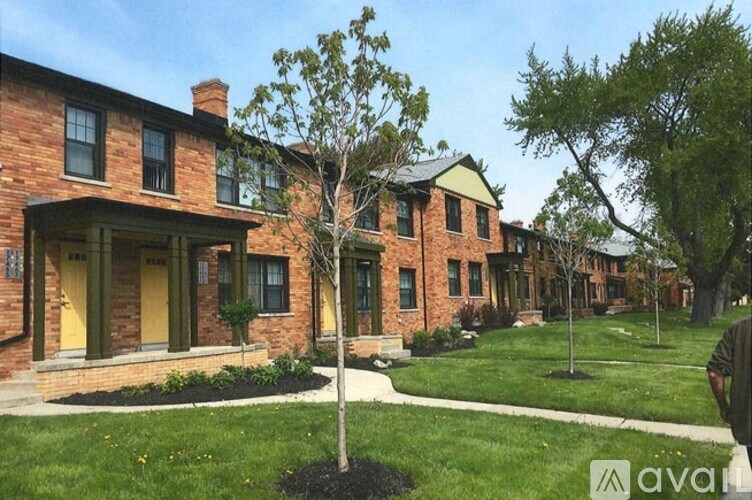 A tree stands in front of a row of houses.