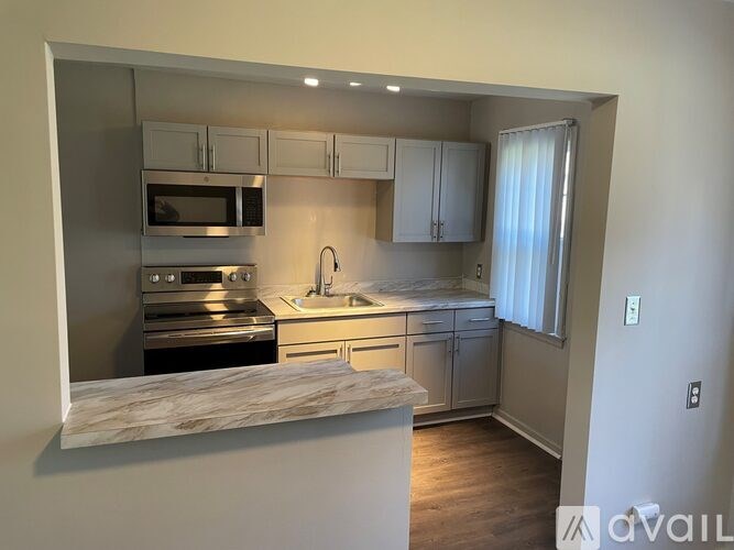 A kitchen with a marble countertop and stainless steel appliances.