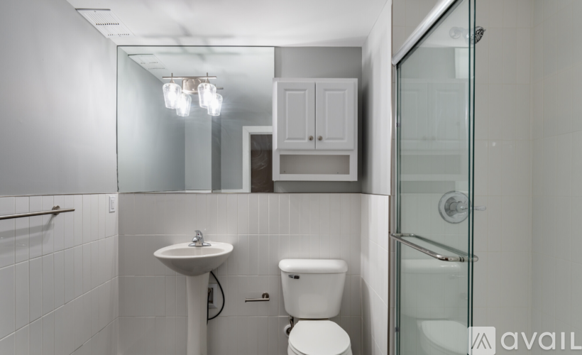 A white bathroom with a sink, toilet and shower.