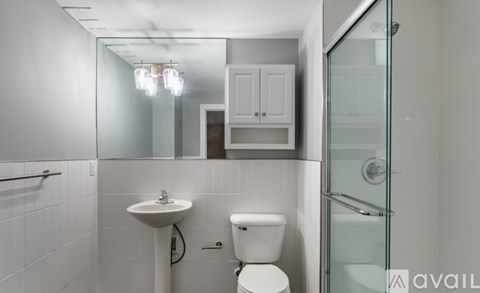 A white bathroom with a sink, toilet and shower.