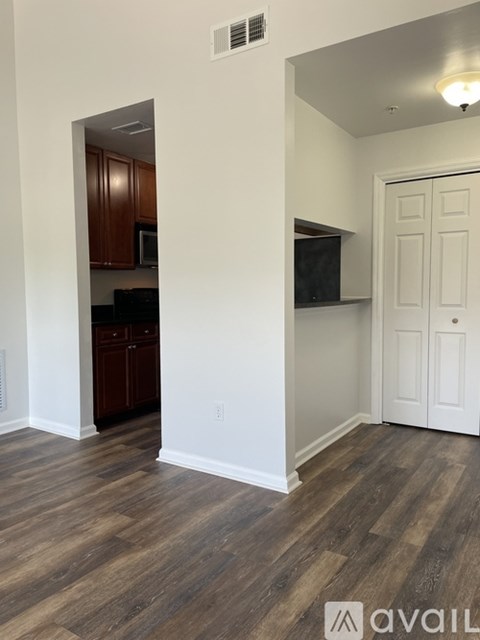 A kitchen with wood floors and white walls.