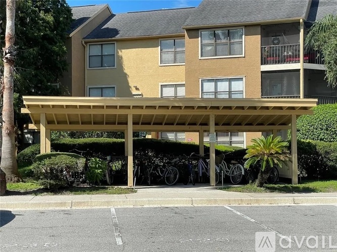 A building with a covered parking area in front.