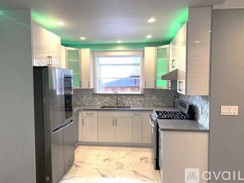 A kitchen with a refrigerator, sink, and stove top oven.