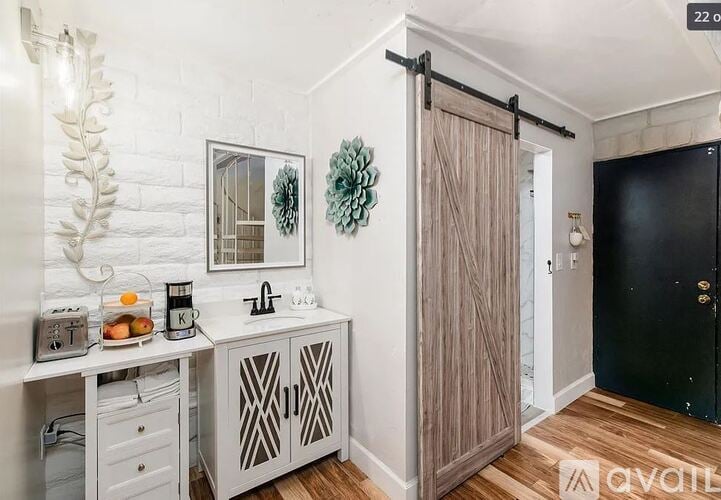 A bathroom with a wooden floor and a black door.