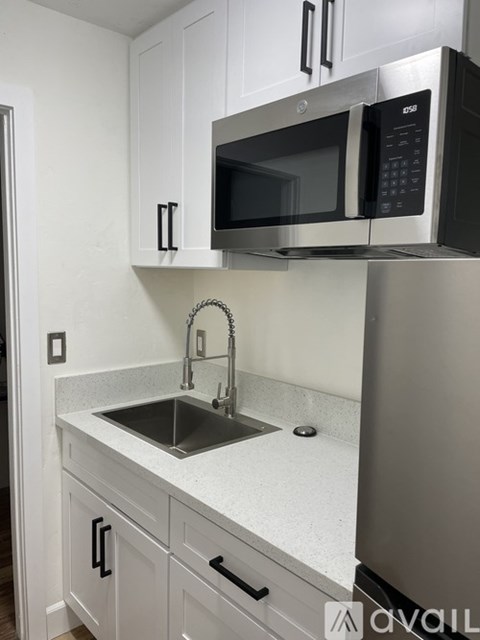 A kitchen with a sink and a microwave above it.