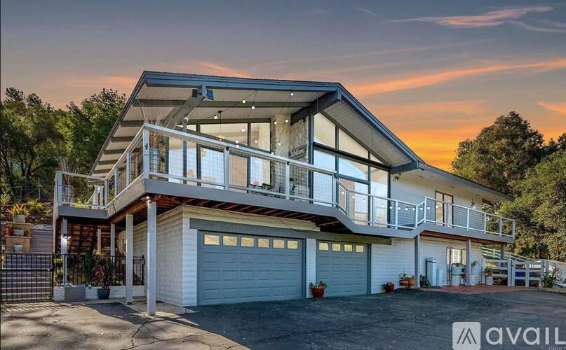 A modern house with a balcony and two garages is available for purchase.