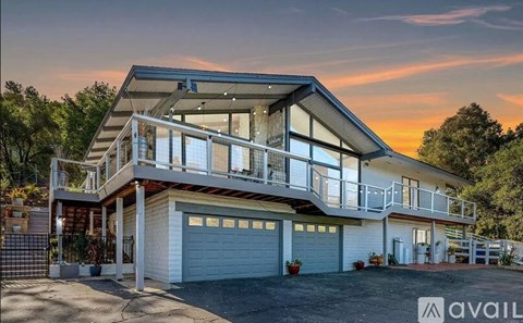 A modern house with a balcony and two garages is available for purchase.