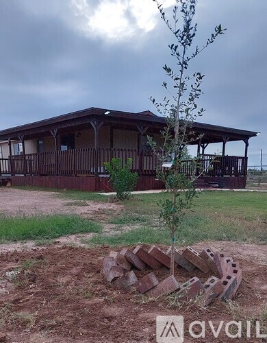 A house with a porch and a tree in front of it.