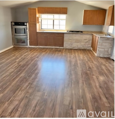 A kitchen with wooden floors and cabinets is available.