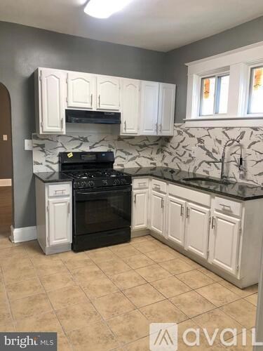 A kitchen with white cabinets and a black stove top oven.
