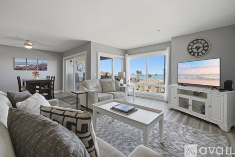 A living room with a large window overlooking the beach.