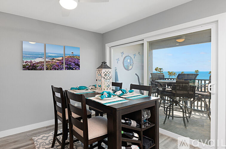 A dining room with a table set for four and a view of the beach.