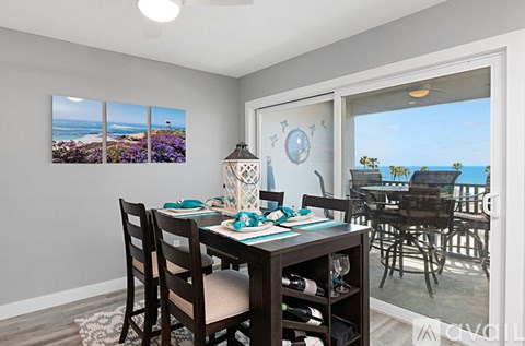 A dining room with a table set for four and a view of the beach.