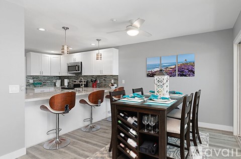 A modern kitchen with a bar area and a dining table set for four.