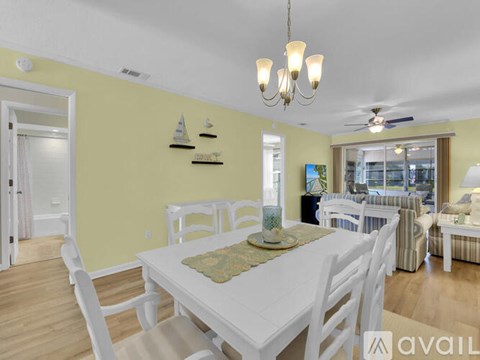 A dining room with a white table and chairs.