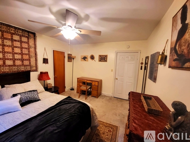 A bedroom with a bed, a ceiling fan, and a rug.