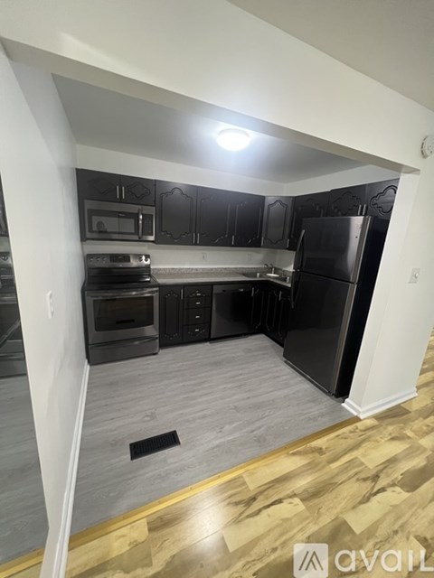 A kitchen with black cabinets and stainless steel appliances.