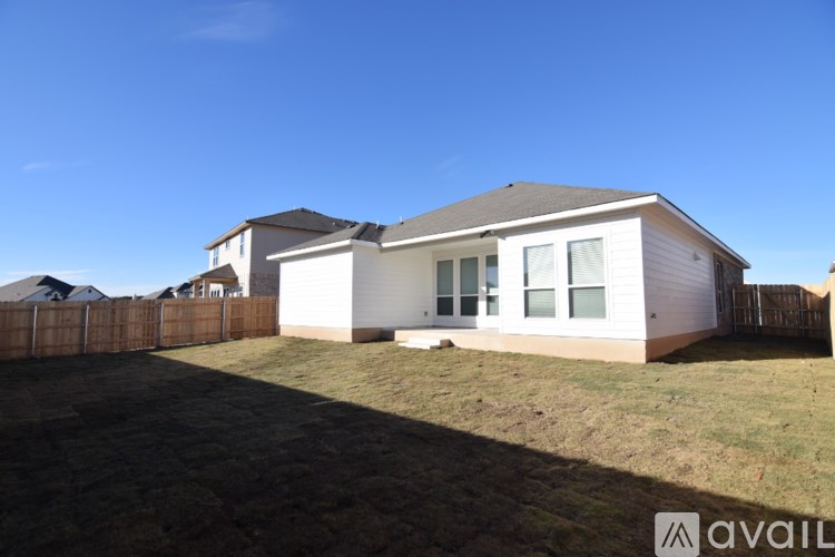 A house with a white exterior and a brown fence is available for sale.