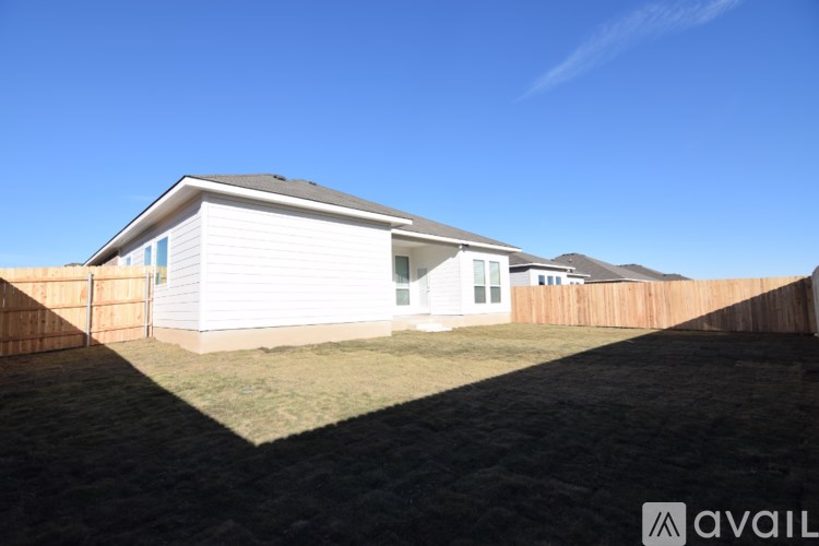 A house with a white exterior and a brown fence is available for sale.