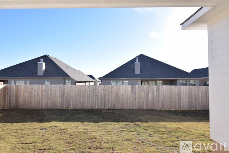 A row of houses with a wooden fence in front.