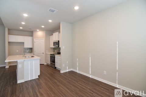 A kitchen with white cabinets and a microwave.