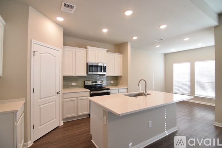 A kitchen with white cabinets and a countertop is available for rent.