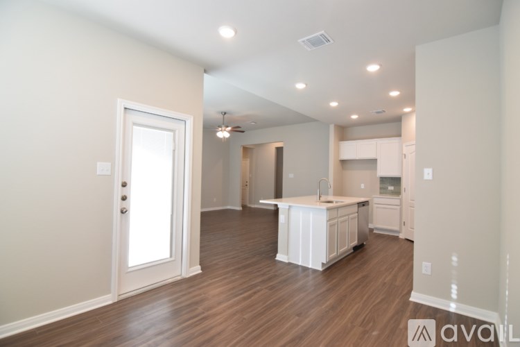 A room with a ceiling fan and three windows with blinds.