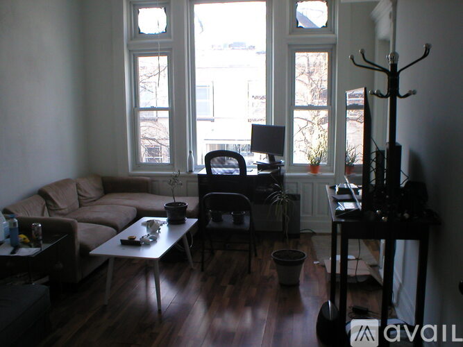 A living room with a couch, a chair, a table, and a television.