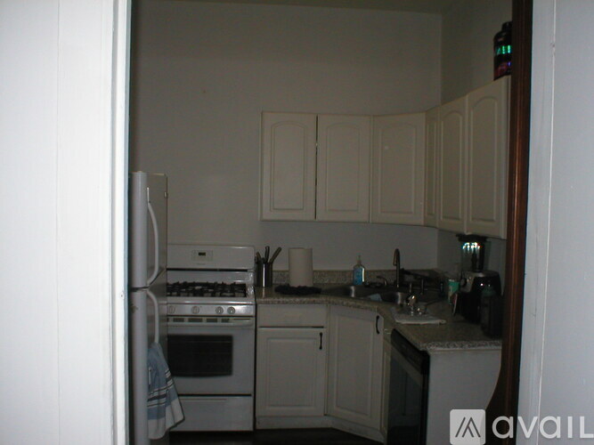 A kitchen with white cabinets and appliances.