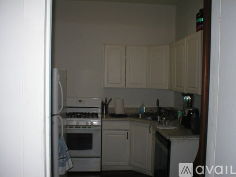 A kitchen with white cabinets and appliances.