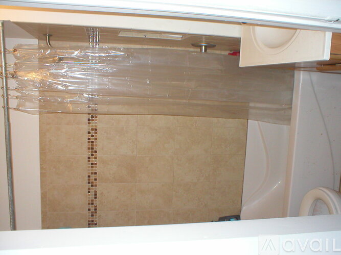 A bathroom with a shower covered in plastic.