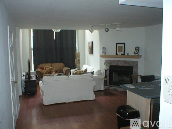 A living room with a white couch and a fireplace.
