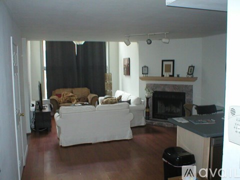 A living room with a white couch and a fireplace.