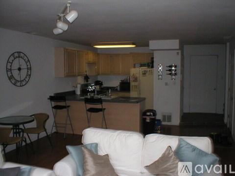 A kitchen with a white couch and a clock on the wall.