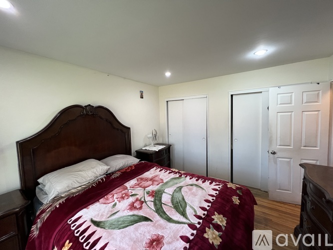 A bedroom with a large bed and a wooden headboard.