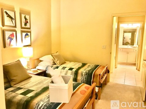 A bedroom with two beds and a dresser with a mirror.