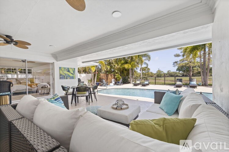 A living room with a pool outside the window.