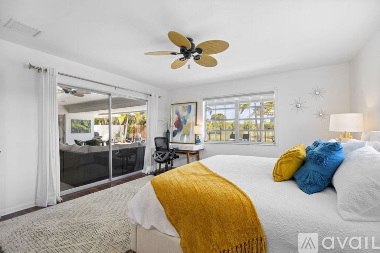 A bedroom with a large bed and a ceiling fan.