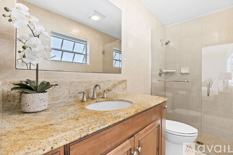 A bathroom with a marble countertop and a white toilet.