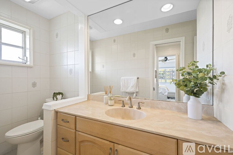 A bathroom with a sink, toilet, and mirror.