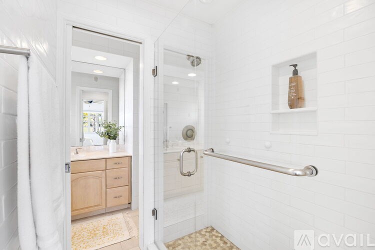 A white bathroom with a white door and a white shower.