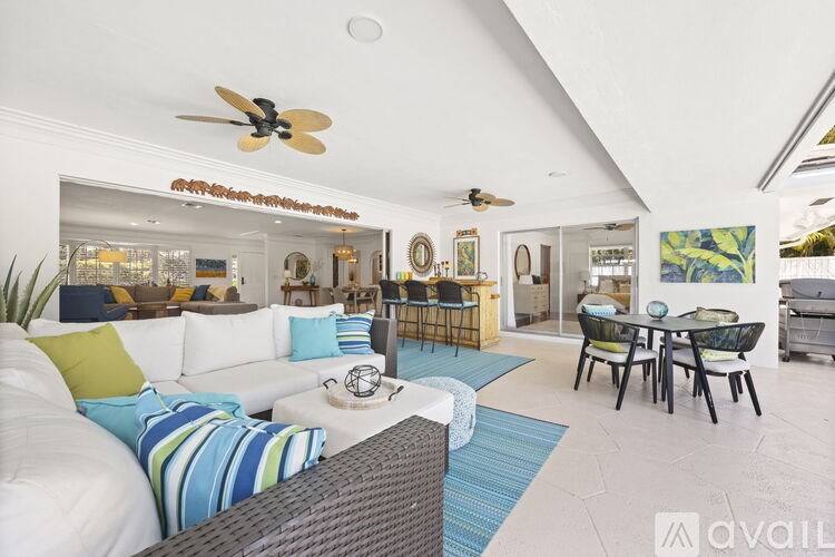 A living room with a white couch and a fan on the ceiling.