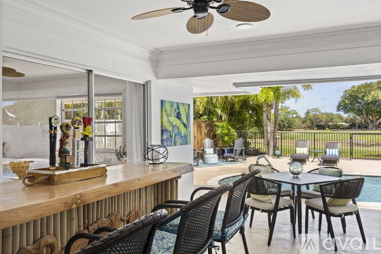 A patio with a table and chairs and a ceiling fan.