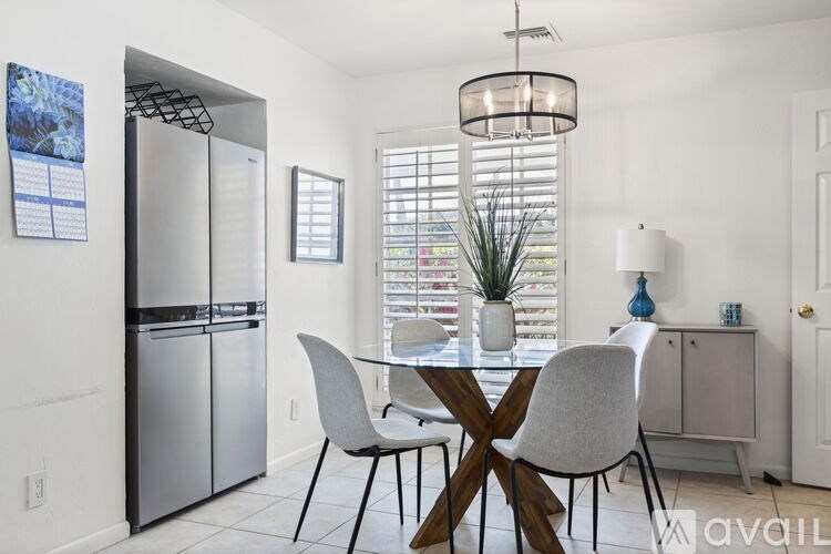 A modern kitchen with a dining table and chairs.