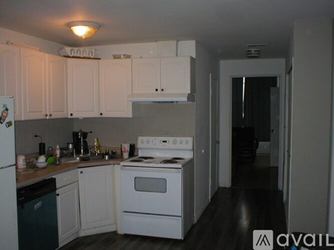 A kitchen with white cabinets and a white stove top oven.