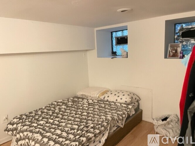 A bedroom with a bed covered in a black and white patterned comforter.
