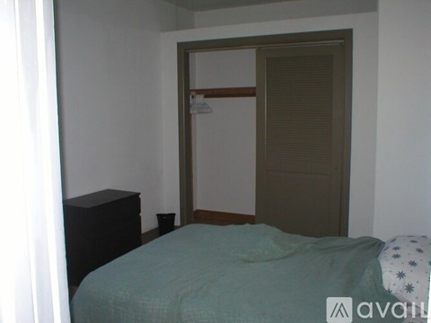 A bedroom with a bed, nightstand and closet.