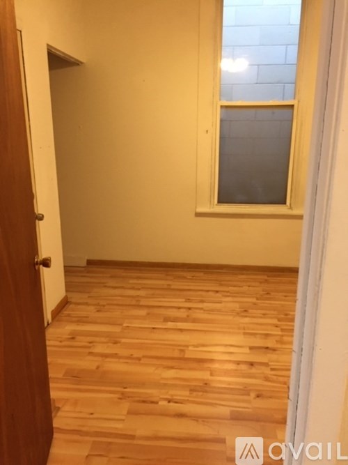 A room with wooden flooring and a window.
