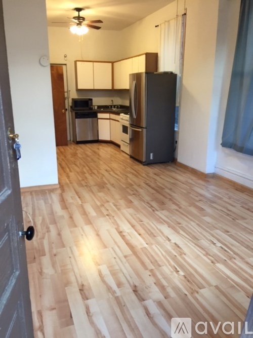 A kitchen with wooden floors and a refrigerator.