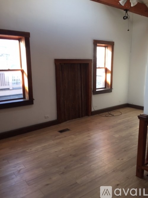 A room with wooden floors and a ceiling fan.